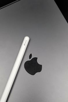 Close-up image of an Apple Pencil resting on a MacBook surface, showcasing technology accessories.
